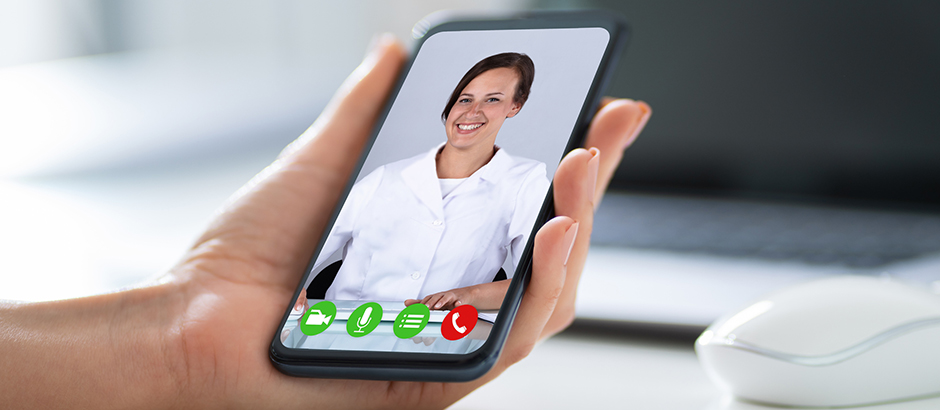 Hand holding a smart phone with an image of a doctor in the screen