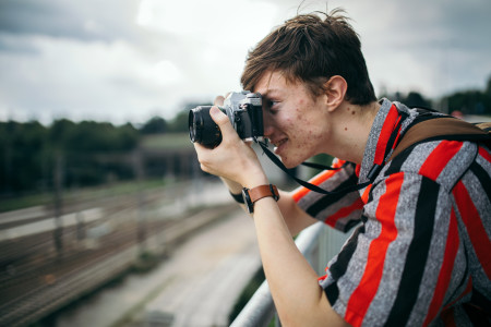 Man with acne looking through binoculars