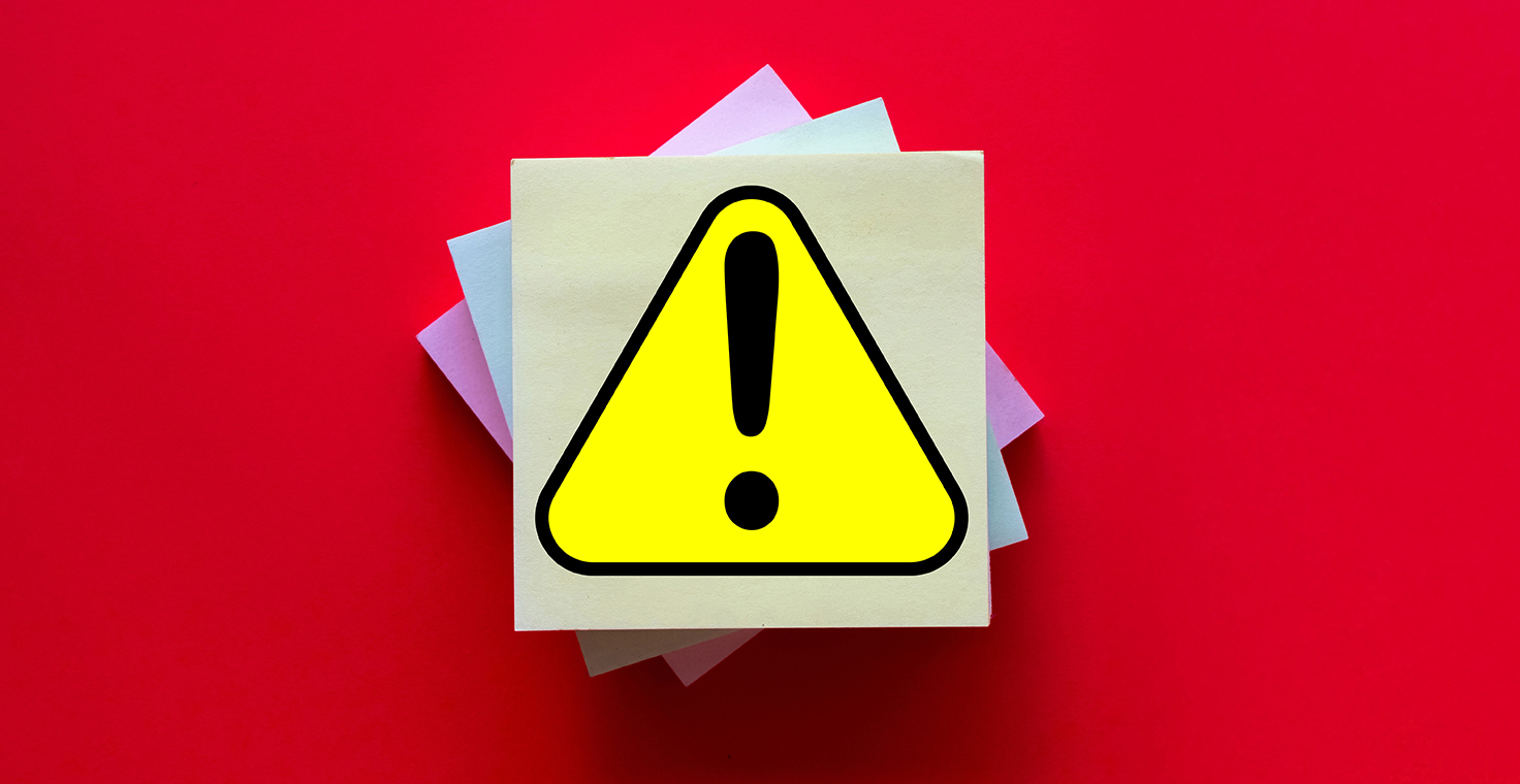 Post-it notes with an exclamation point against a red background to illustrate workplace safety.