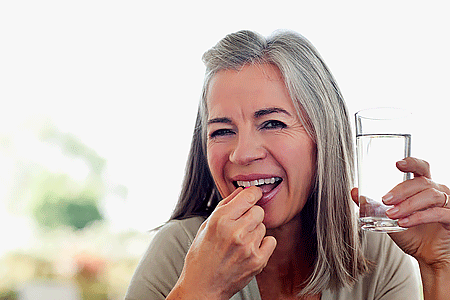 Woman taking medication to treat shingles