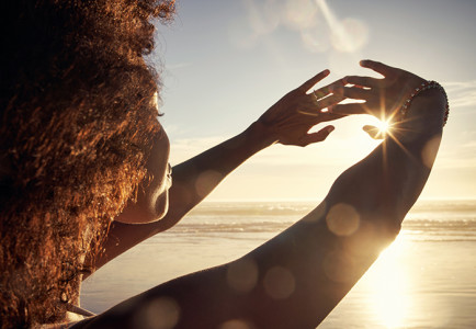 Young woman blocking the sun with her hands