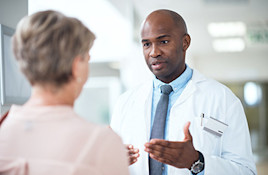 Image of a dermatologist helping a patient understand her condition | American Academy of Dermatology (AAD)