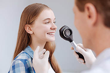 Dermatologist examining a young girls skin