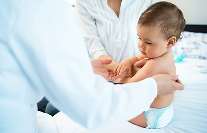 A dermatologist examining a birthmark on a baby