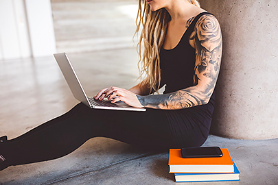 tattooed woman on laptop