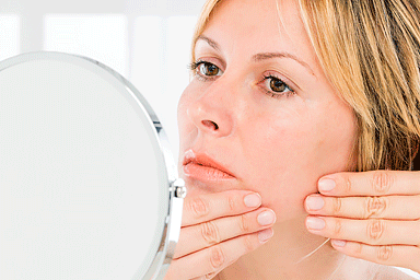 Woman looking at face in mirror