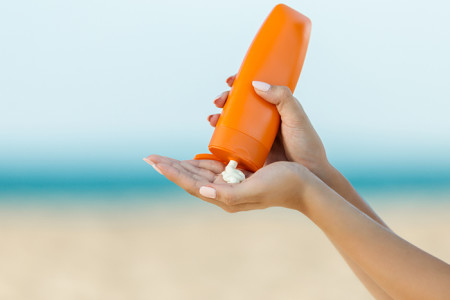 Sunscreen being squeezed out of a bottle