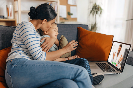 Mother with young child using telemedicine to visit an online medical clinic about a skin concern