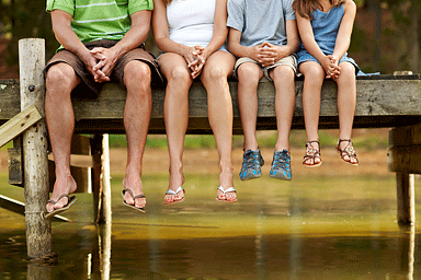 Family sitting on pier wearing flip-flops
