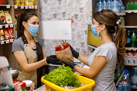 Cashier and shopper wearing face masks