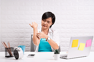Woman scratching her arm during telemedicine appointment