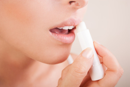 Woman applying lip balm to her healthy lips