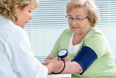 woman getting her blood pressure taken in doctor's office