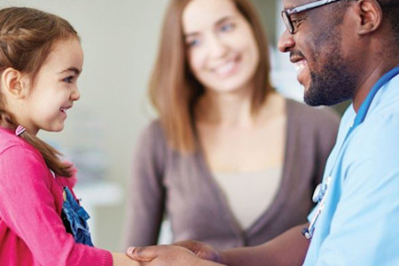Dermatologist examining a young patient with skin of color
