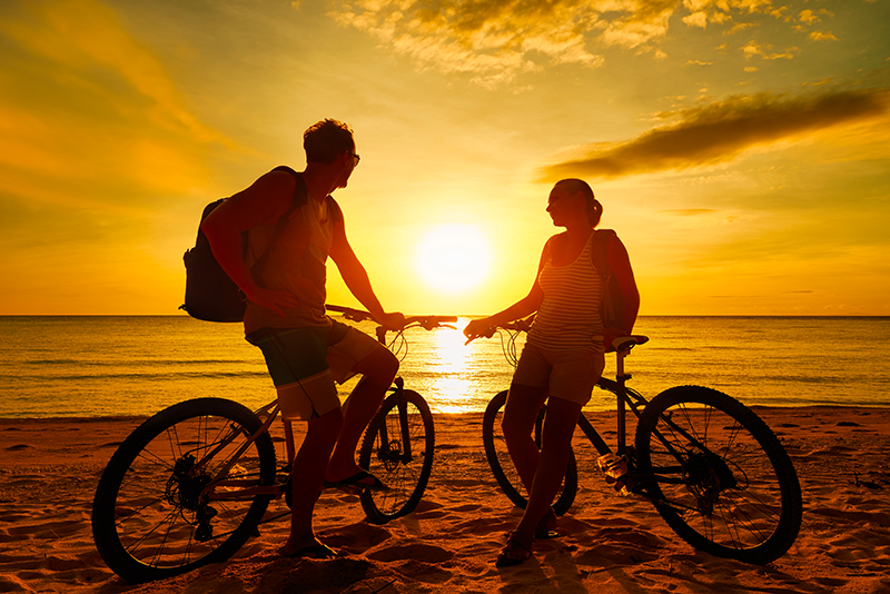 A couple with their bicycles watching sunset