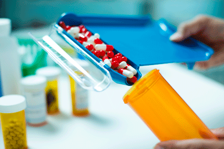 Pharmacist filling a prescription bottle with pills