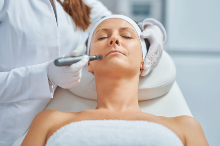 Woman having microneedling treatment by a dermatologist.