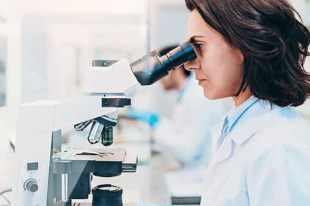Close-up of a female doctor looking through a microscope