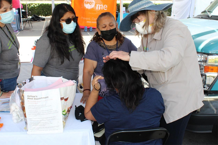 Doing an AAD SPOT skin cancer check in 2022 at a community outreach event.