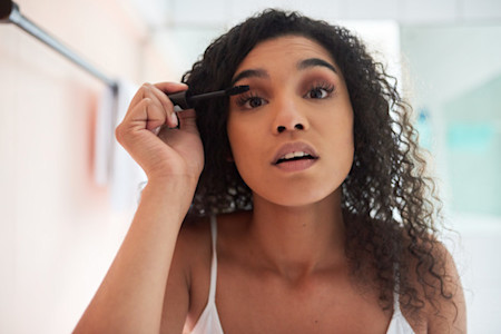 Image of woman applying mascara onto her natural lashes