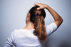 Woman scratching her scalp