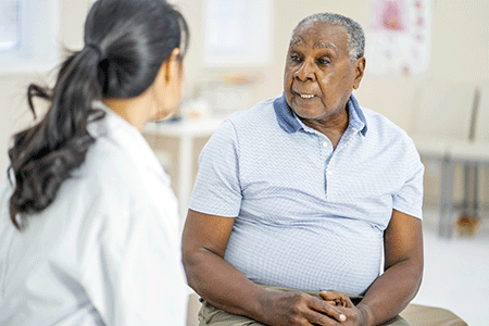 Patient with mycosis fungoides talking with his dermatologist during an in-office appointment