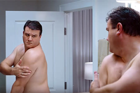 Man checking skin on the back of his body in the mirror