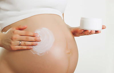 Woman applying lotion to stretchmarks