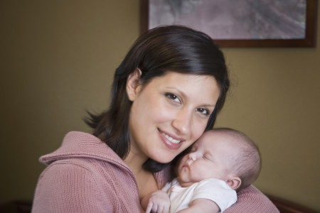 Hispanic mother hugging baby