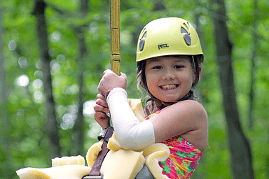 Camp Discovery attendee smiling while zip-lining