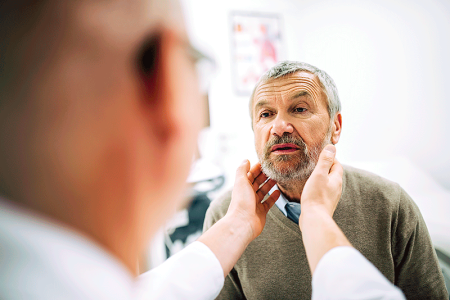 Dermatologist examining patient’s neck.