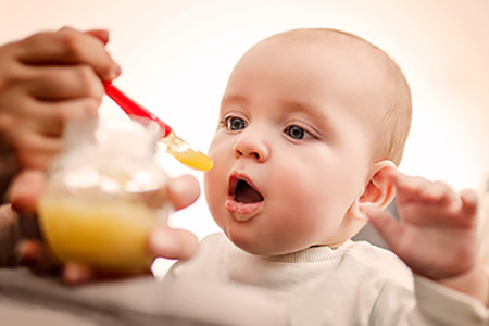 Baby eating. Parents often experiment with food in hopes of curing eczema, but research shows this seldom works.