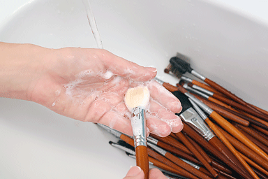 Washing makeup brushes with soap in the sink