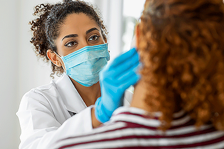Dermatologist examining rash on patient’s face