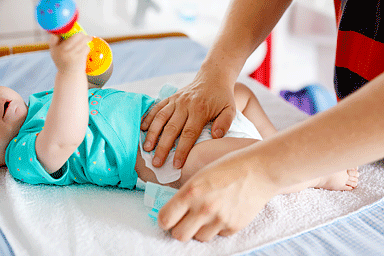 Close-up of father changing diaper of his newborn baby daughter