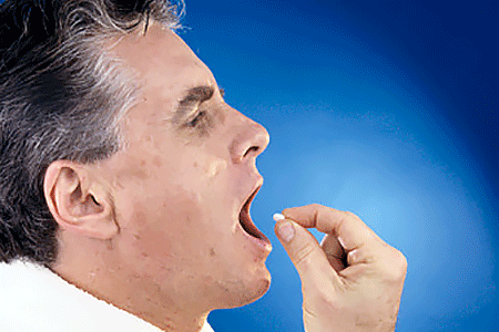 Man putting a pill in his mouth