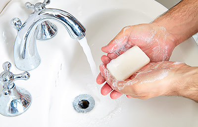 Gentleman washing hands to avoid spreading the cold sore virus