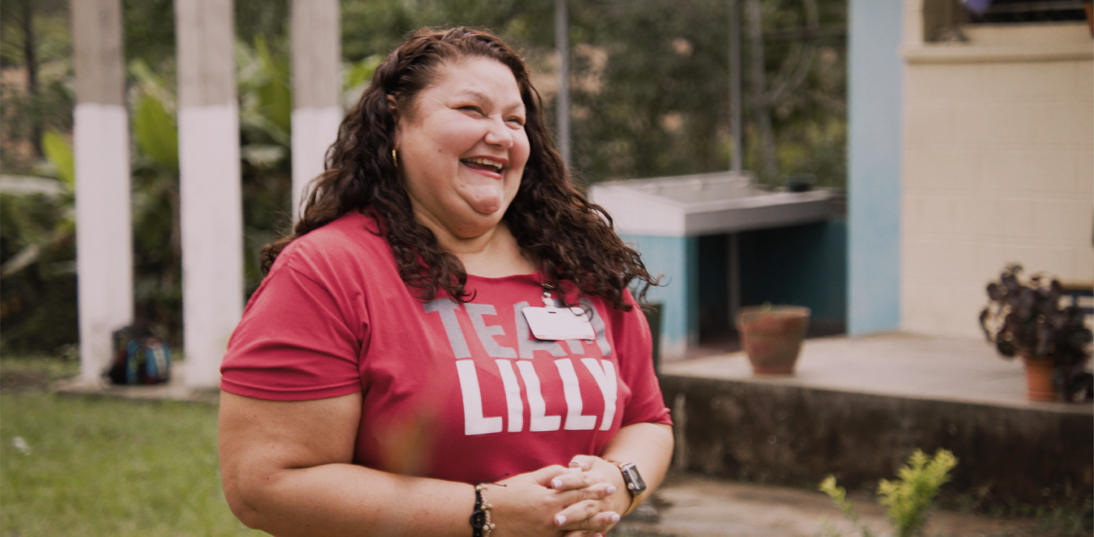 Woman smiling, wearing a red Team Lilly shirt