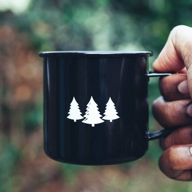 Black mug with white nordic tree motif.