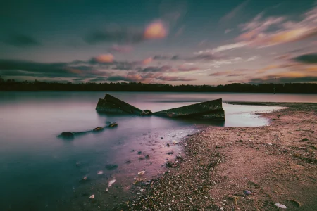 Ein im Wasser liegender Anker, eingtaucht im Licht eines Sonnenuntergangs.