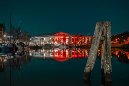 Die Musik- und Kongresshalle in Lübeck in rotem Licht.