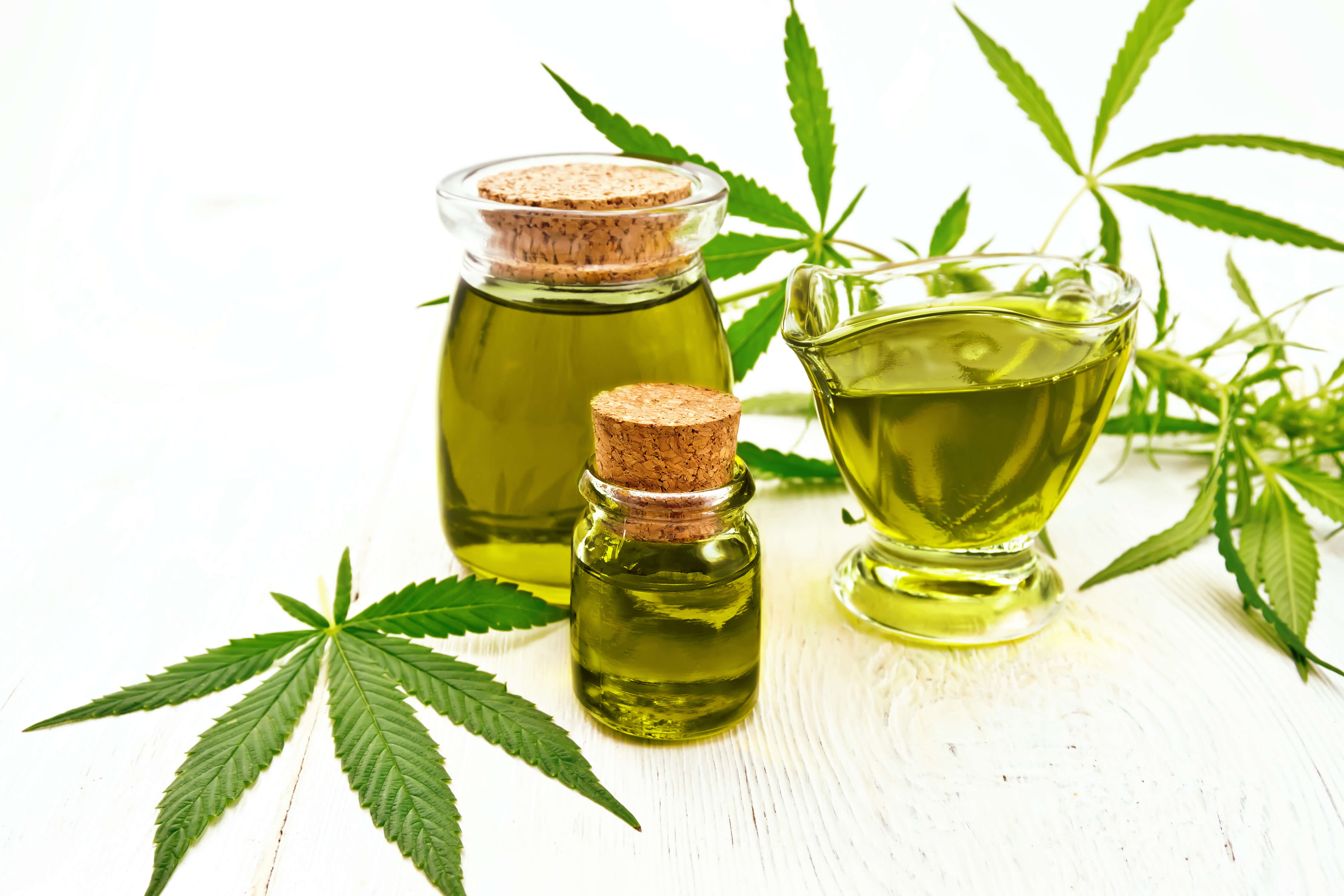 CBD vs THC: Know The Key Differences 4 A few vials of CBD oil next to the hemp plant.