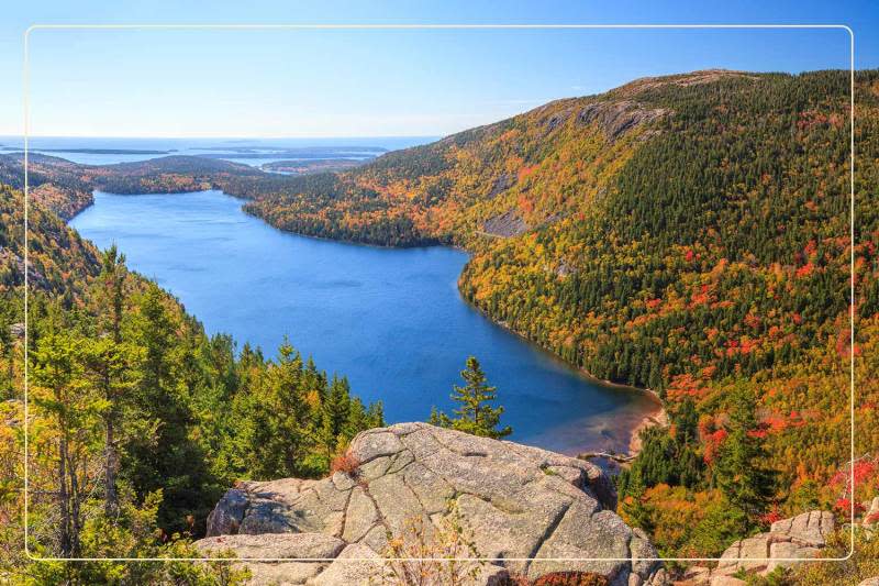 an aerial view of a lake surrounded by fall foliage at Acadia National Park, a dog-friendly national park where one can go hiking with dogs