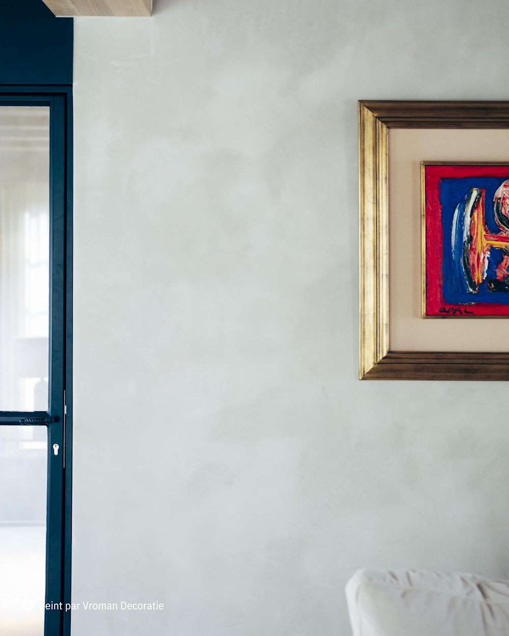 Salon moderne avec mur en Calco et œuvre colorée dans un cadre doré