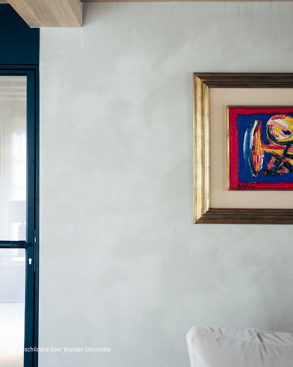Moderne woonkamer met Calco-muur en kleurrijk kunstwerk in gouden lijst