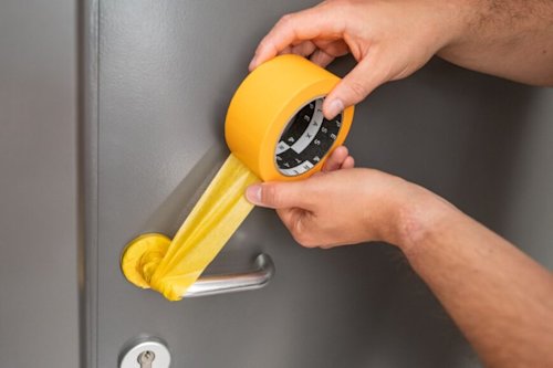 Porte grise recouverte de ruban jaune