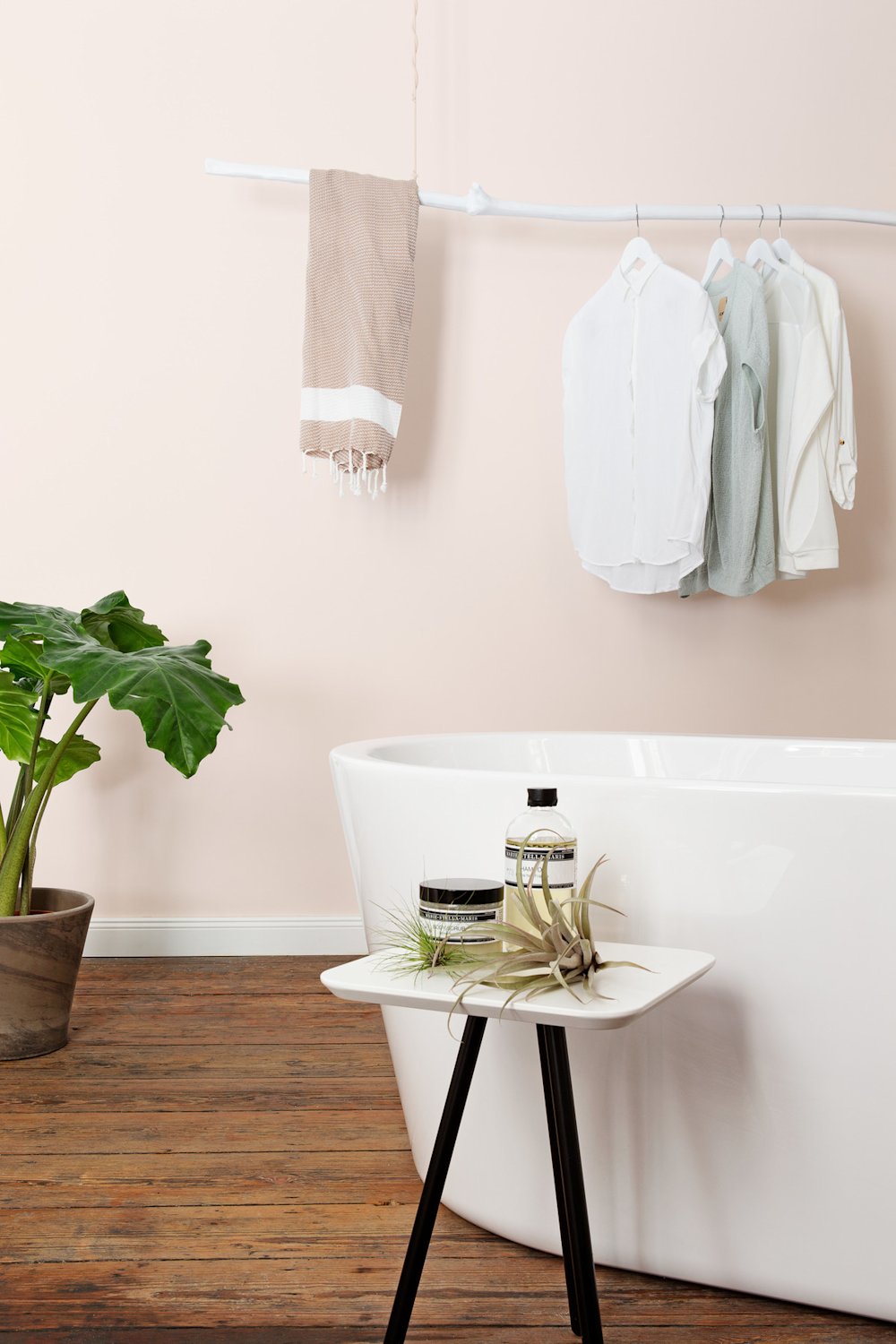 Colora – zachtroze muren, donker houten vloer en wit losstaand bad