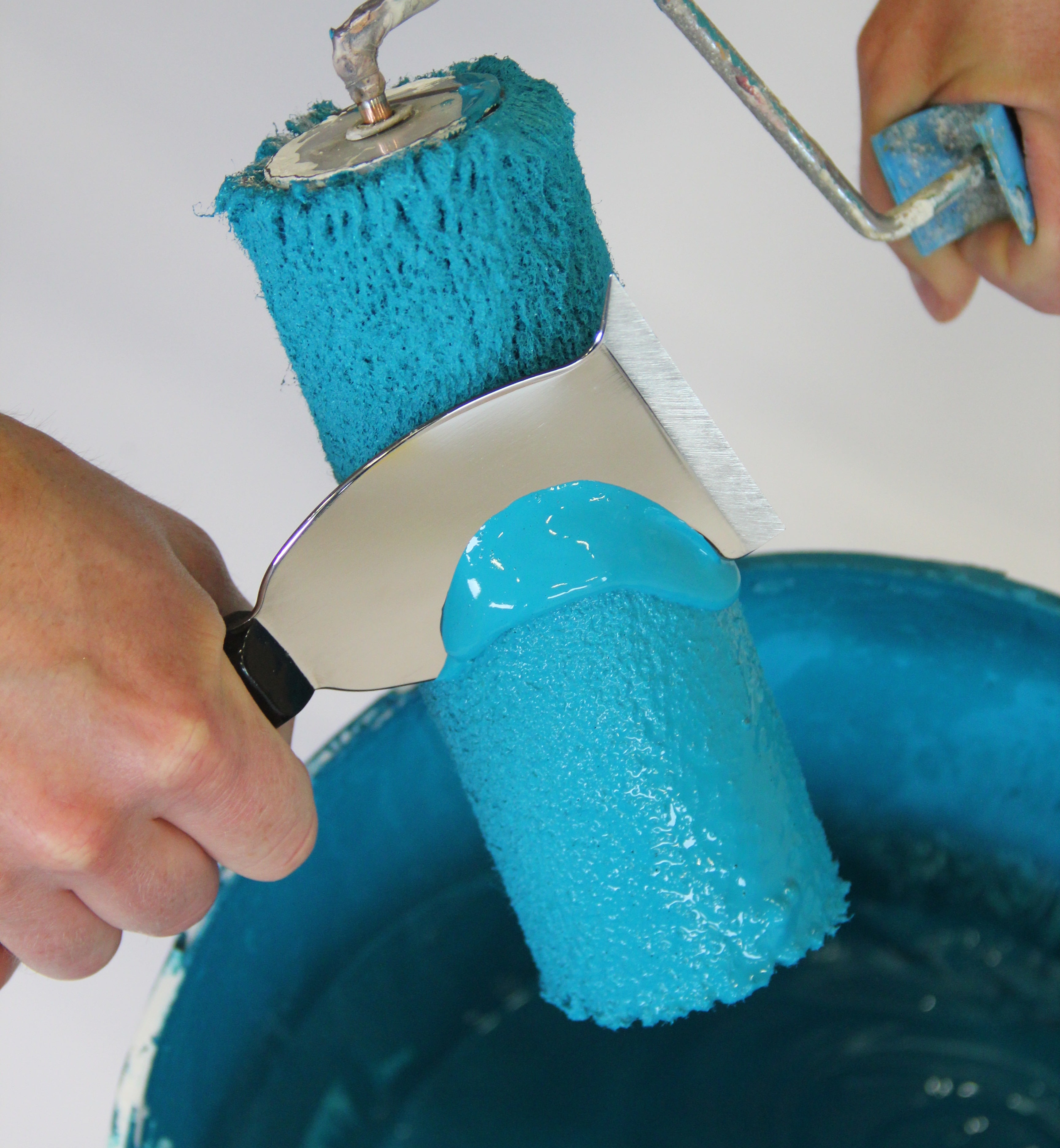 met een multifunctioneel mes overtollige verf uit de verfrol verwijderen