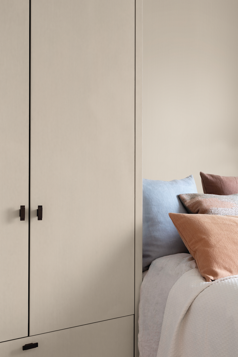 Colora-slaapkamer met grijze kasten en muur en kleurrijke kussens