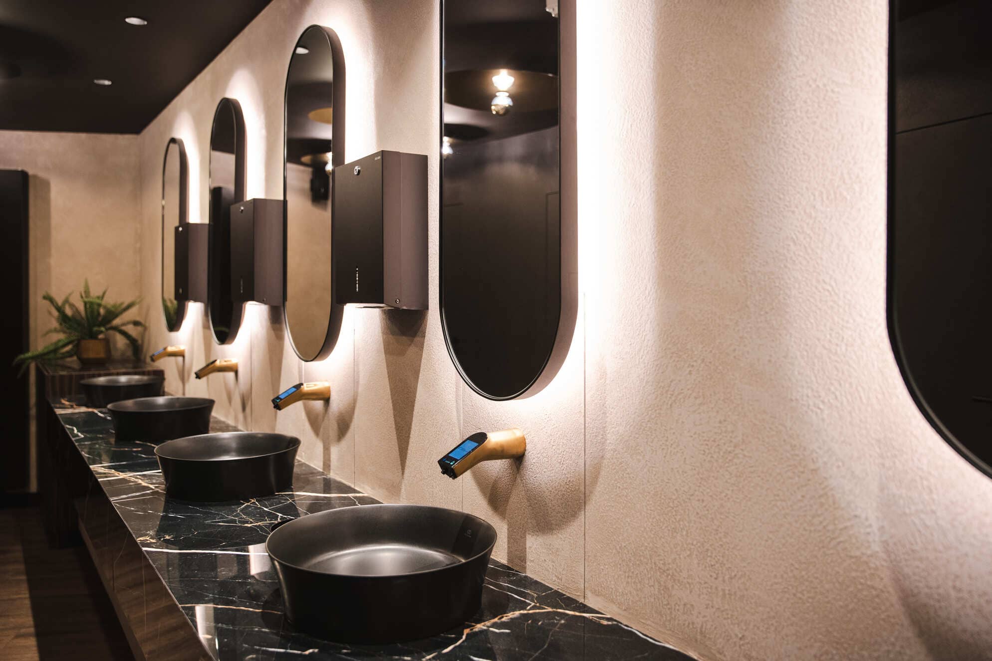 Technique décorative Stone Art dans les toilettes de l'hôtel Van der Valk à Beveren. Lavabos avec miroirs éclairés et Stone Art au mur dans une couleur beige. Image mensongère.